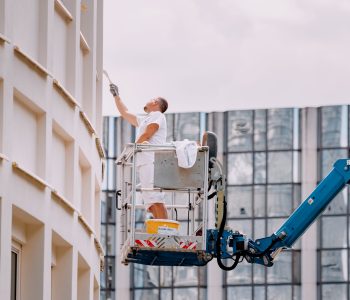27 July 2022, Essen, Germany: A male worker paints a historic building in the old city center. Restoration and repair 27 July 2022, Essen, Germany: A male worker paints a historic building in the old city center. Restoration and repair